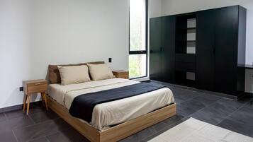 Une chambre moderne avec un lit, des tables de chevet, une armoire et une grande fenêtre.
