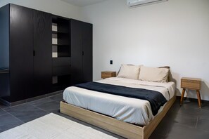 A modern bedroom with a bed, a wardrobe, and a nightstand. - Xpuha Villa, Private Pool and Jungle, Near Beach (Xpu Ha)