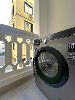 Un lave-linge à chargement frontal, muni d’un autocollant indiquant une garantie de 10 ans sur le moteur.