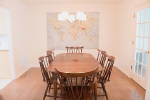A dining room with a wooden table and chairs, a chandelier, and a world map on the wall. - Child-Friendly Retreat Near Charleston, 2 (Hanahan)