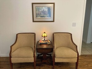 Two armchairs facing each other with a small table between them, a lamp on the table, and a framed picture on the wall. - Child-Friendly Retreat Near Charleston, 2 (Hanahan)