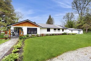 A single-story house with a front porch, a garage, and a small attached structure. - Lakefront, dog-friendly house with amazing view, dock, 2 kayaks & canoe (Isle La Motte)