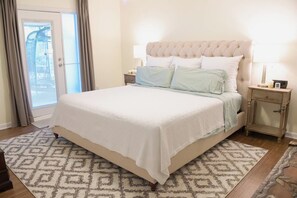 A bedroom with a bed, bedside tables, a patterned rug, and a view through a door. - Child-Friendly Retreat Near Charleston (Hanahan)