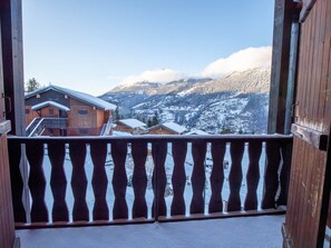 A balcony with a view of snow-covered mountains and wooden buildings. - Quiet apartment by the forest - 4/6 guests (Villarodin-Bourget)