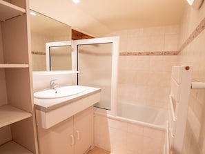 Ein Badezimmer mit Waschbecken, Spiegel und Badewanne.