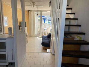 A room with a sofa, a ceiling fan, a staircase, and a view of the outside. - Duplex with parking - 6 guests in quiet area (Le Grau-du-Roi)