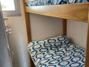A bunk bed with a patterned mattress and a window above. - Duplex with parking - 6 guests in quiet area (Le Grau-du-Roi)
