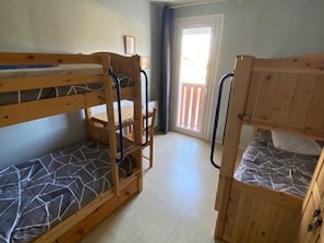A room with bunk beds, a door leading outside, and a window. - Practical studio, balcony & chalet view - 8 guests (Arette)