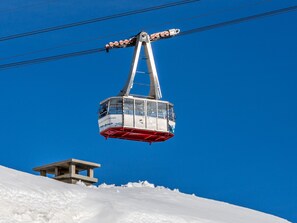 A cable car suspended above a snowy landscape with a clear blue sky. - Luxury apartment with parking - 6 guests (Val-d'Isère)