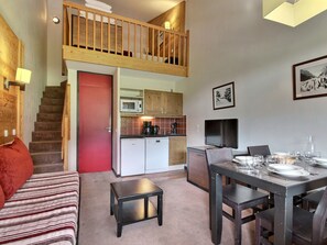 A compact living space with a kitchen, dining area, and a small seating area. - Charming duplex, slopes view - 4 guests (Belle Plagne)