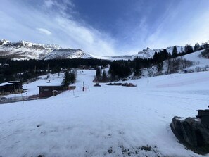 A snow-covered mountain landscape with a ski resort, including buildings and ski lifts. - Bright studio at the foot of the slopes (Valmorel)