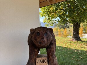 A wooden sculpture with a carved face, labeled "ZAHO," placed outdoors with a tree and grass in the background. - Modern house in village center - 12 guests (Villard-de-Lans)