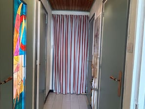 A hallway with striped curtains, a colorful stained glass window, and wooden doors. - 2-room apartment by the slopes - 4 guests (Huez)