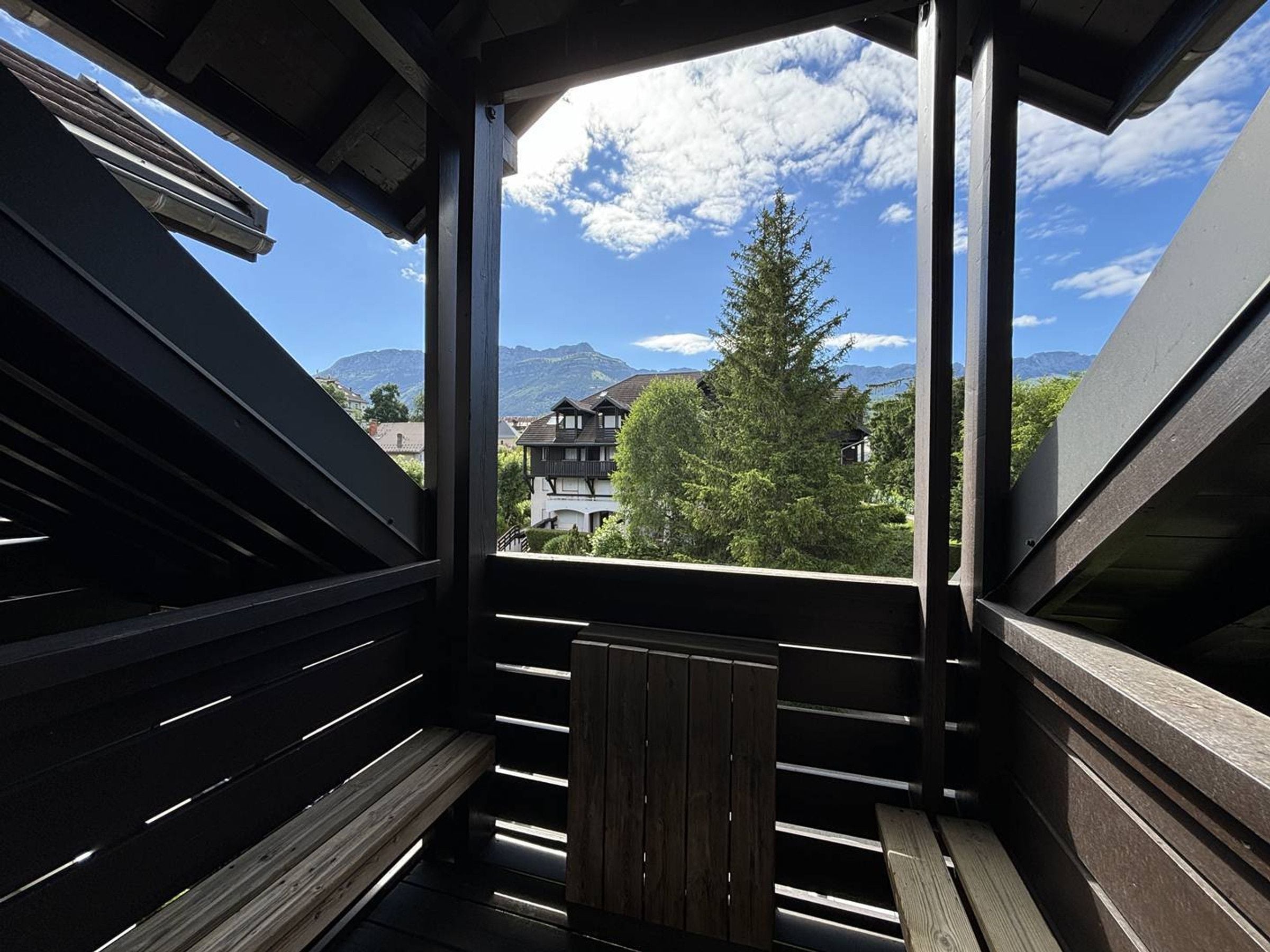 Un balcón con vistas a montañas y casas.