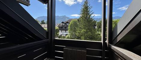 Un balcón con vistas a montañas y casas.