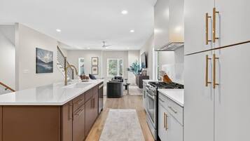 A modern kitchen with a central island, stainless steel appliances, and wooden cabinetry.