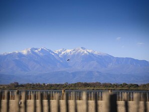 A mountain range with snow-capped peaks and a body of water in the foreground. - Spacious apartment, sea view - 4 guests (Canet-en-Roussillon)