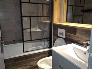 Ein Badezimmer mit Duschkabine, Toilette und Waschbecken.