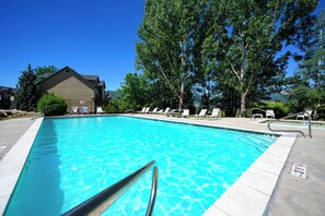 A clear blue pool with a metal ladder, surrounded by lounge chairs and trees. - Modern Mountain Escape MH404 |Hot Tub |Pool | Golf (Eden)