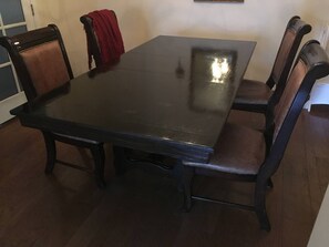 A rectangular dining table with four chairs, each with a cushioned seat and a high backrest. - Family-Friendly Retreat Near Charleston (Hanahan)
