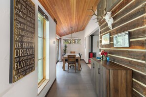 A wooden interior with a dining area, kitchen, and a wall with motivational quotes. - Downtown | On Bus Route | Garage Gear Storage | Pet Friendly (Steamboat Springs)