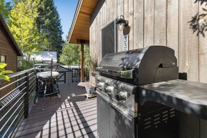 An outdoor patio with a barbecue grill, a wooden deck, and a table with chairs. - Downtown | On Bus Route | Garage Gear Storage | Pet Friendly (Steamboat Springs)