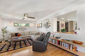 A modern living room with a sofa, armchair, coffee table, and a bookshelf. - Downtown | On Bus Route | Garage Gear Storage | Pet Friendly (Steamboat Springs)