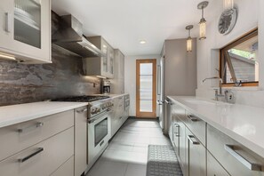 A modern kitchen with stainless steel appliances, a built-in oven, and a large window. - Downtown | On Bus Route | Garage Gear Storage | Pet Friendly (Steamboat Springs)