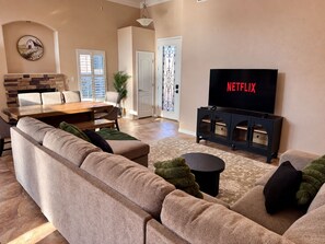 Ein Wohnzimmer mit einer Couch, einem Couchtisch, einem Fernseher und einem Kamin.
