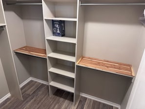 A closet with white shelving units, some with wooden shelves, and a box on one of the shelves. - Beautiful 3-bedroom 2 Bath house with AC in charming El Paso (El Paso)