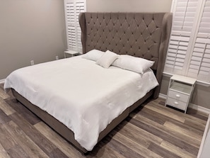 Ein Schlafzimmer mit einem großen Bett, einem Nachttisch und einer Nachttischlampe.