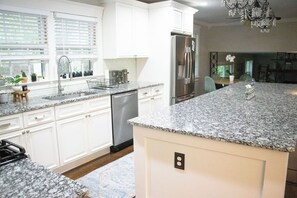 A kitchen with white cabinets, granite countertops, stainless steel appliances, and a chandelier. - 3BR house in charming Columbia close to USC, Fort Jackson and Prisma Health (Columbia)