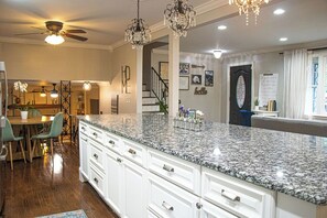 A spacious kitchen with granite countertops, white cabinetry, and a dining area with a wooden table and chairs. - 3BR house in charming Columbia close to USC, Fort Jackson and Prisma Health (Columbia)