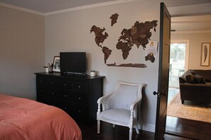 A bedroom with a bed, a dresser, a television, a world map on the wall, and a door leading to another room. - 3BR house in charming Columbia close to USC, Fort Jackson and Prisma Health (Columbia)