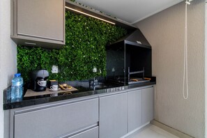 Eine moderne Küche mit grüner Wand, einer Kaffeemaschine und einem Spülbecken.
