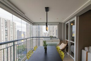 Ein Balkon mit Esstisch, Stühlen und einem Blumentopf.