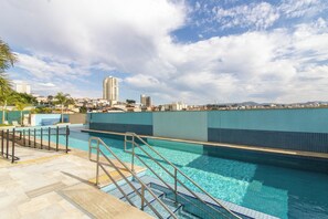 A swimming pool with clear blue water, surrounded by a tiled deck and metal railings. - Maia Supreme Apartment 012207 5 min Shopping Maia (Guarulhos)
