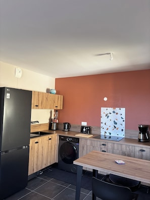 A compact kitchen with a refrigerator, washing machine, coffee maker, and a toaster. - Air-conditioned apartment, free underground parking (Sanary-sur-Mer)