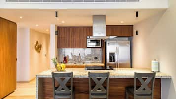 A modern kitchen with granite countertops, stainless steel appliances, and wooden cabinetry.