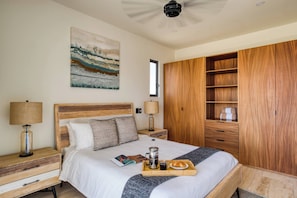 A neatly arranged bedroom with a bed, bedside tables, a wooden wardrobe, and a painting on the wall. - Family Friendly Apt- 17 Ocean View, 3br, 6 pax (Cabo San Lucas)
