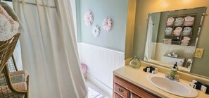 A bathroom with a white sink, a mirror, a towel rack with folded towels, and a radiator. - Historic Bed & Breakfast 8 Bedrooms, Groups/family (Eureka Springs)