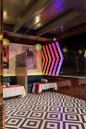 A modern interior with a patterned floor, seating area, and a wall with a geometric light installation. - Dawnland By OPO Essential  (Itanagar)