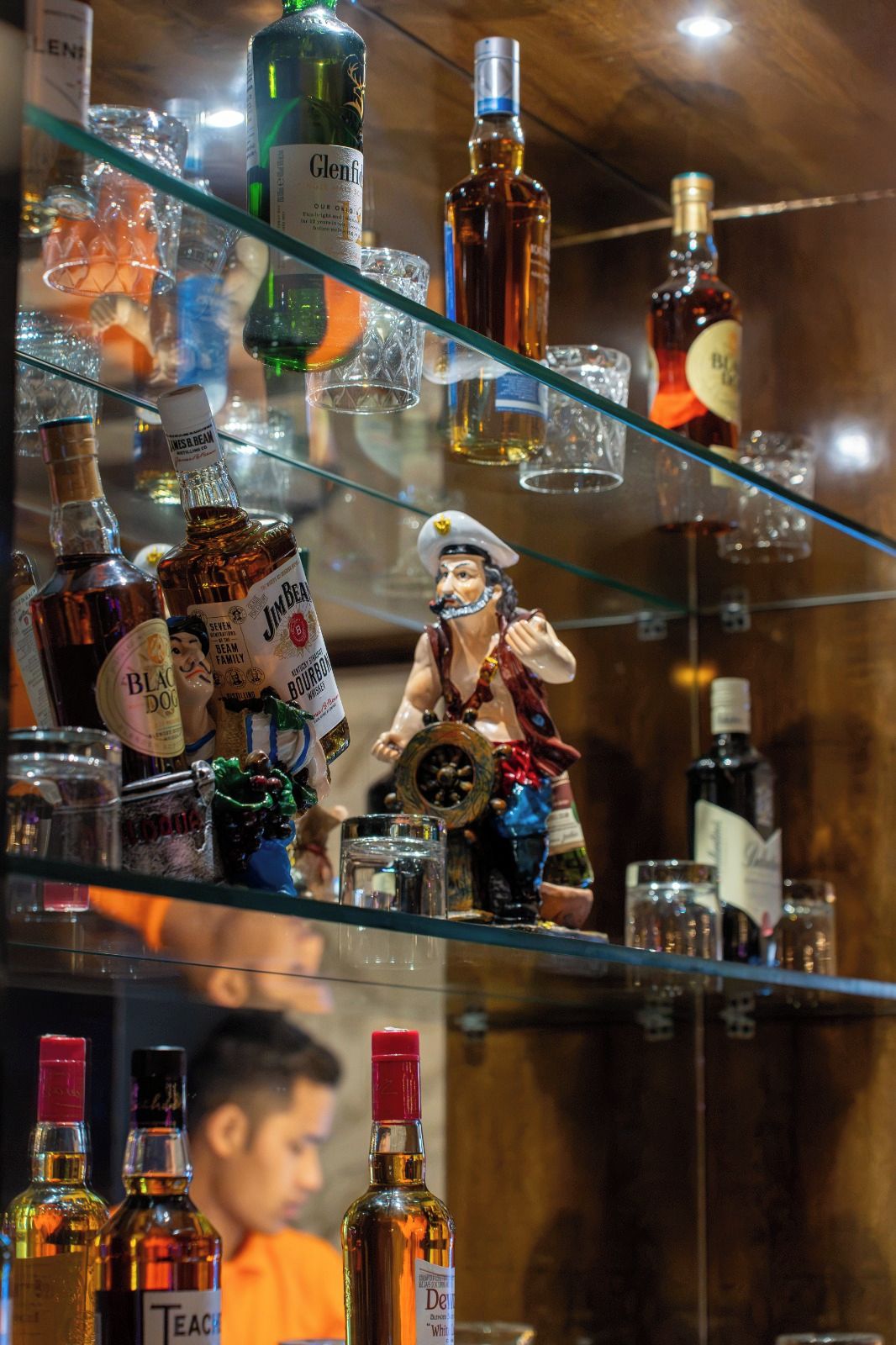 Eine Bar mit verschiedenen Flaschen und einer dekorativen Figur.