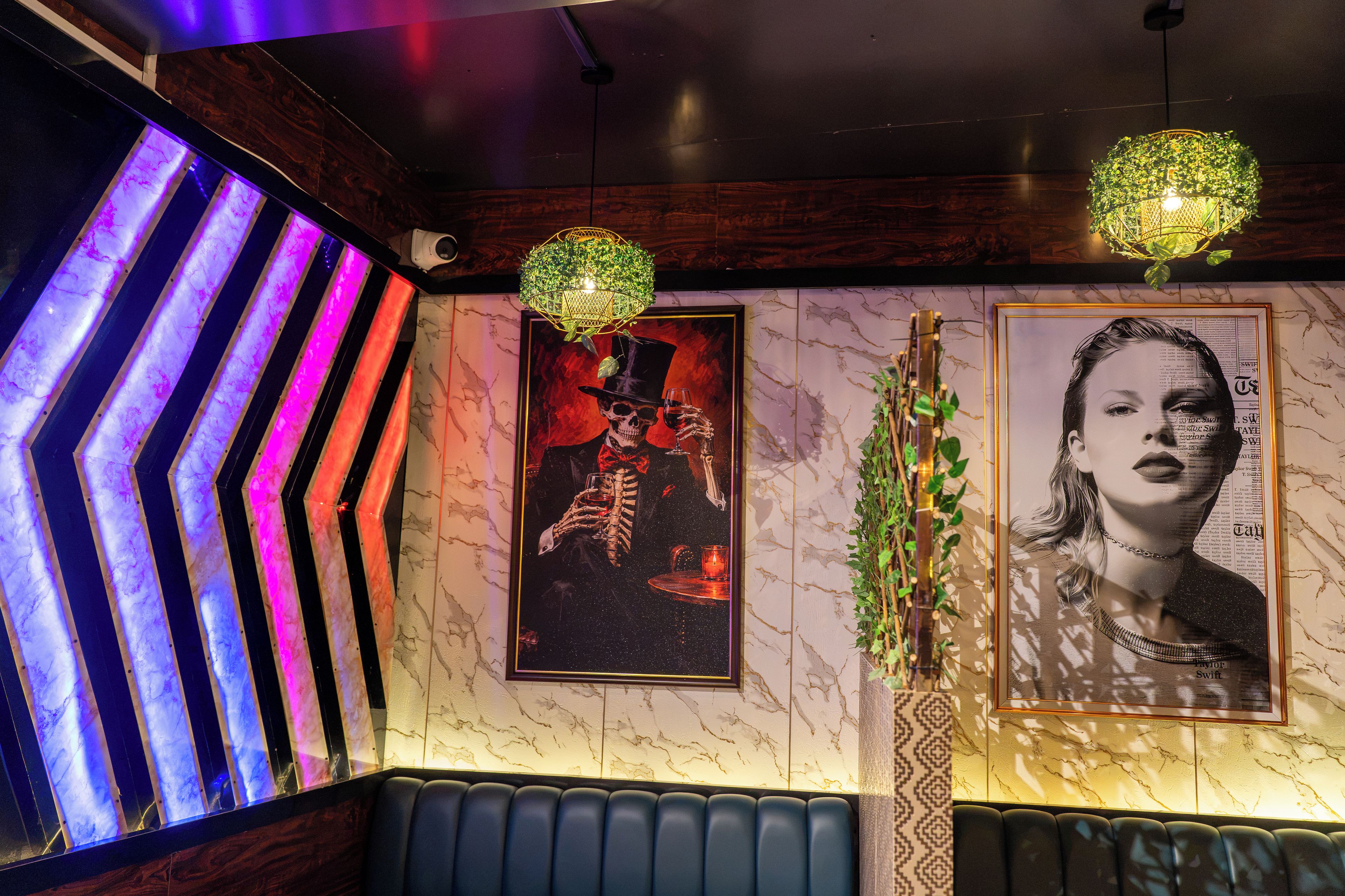 A room with a marble wall, a poster of a skeleton, and a neon light.