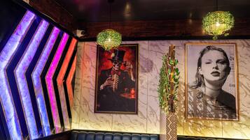 A room with a marble wall, a poster of a skeleton, and a neon light.