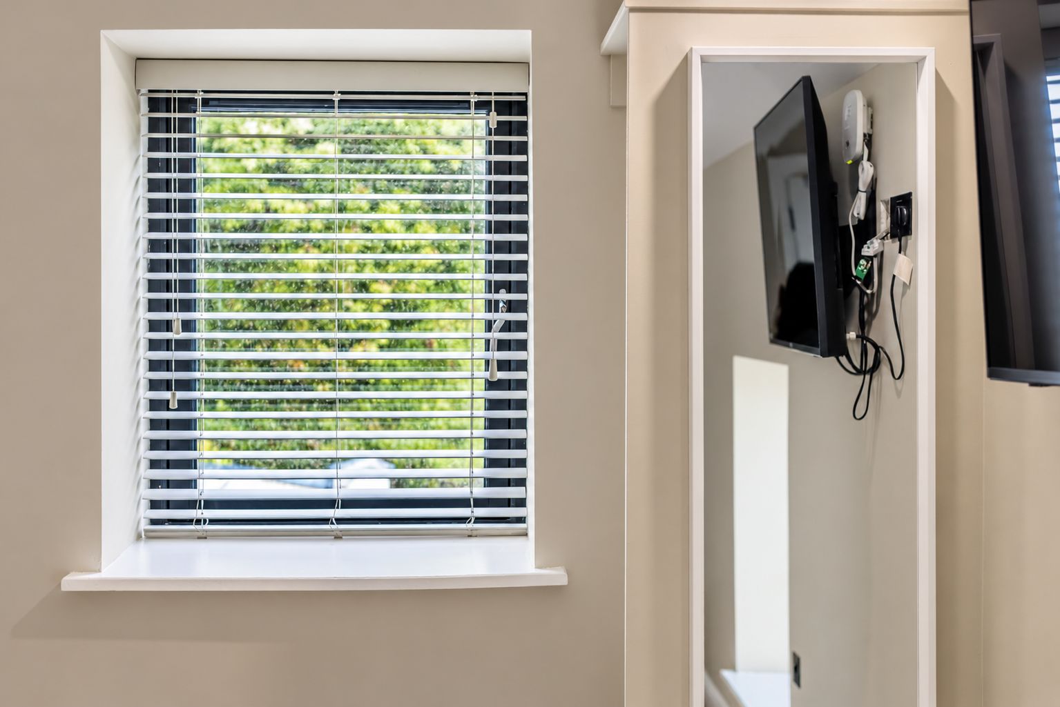 Bright room with natural light, garden views, and wall-mounted TV