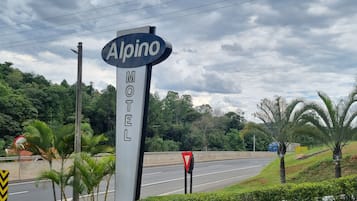 A sign for the Alpine Motel with a road in the background.