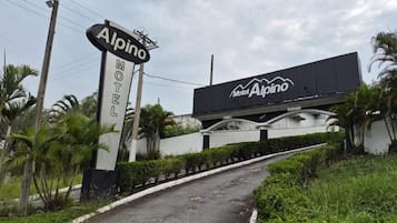 Een motelbord met de naam 'Alpino' en een grote reclameborden erboven.