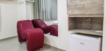 A room with two massage chairs, a small table, and a white cabinet.