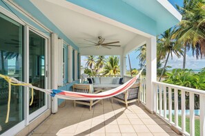 A covered outdoor area with a hammock, seating, and a view of the ocean. - Cielo y Mar Beach House | Direct Beach Access (Humacao)